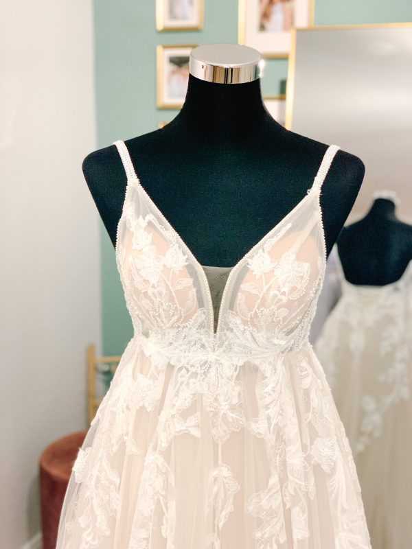 ein romantisches Brautkleid mit Spitzenbesetztem Tüllrock und Perlenträgern.